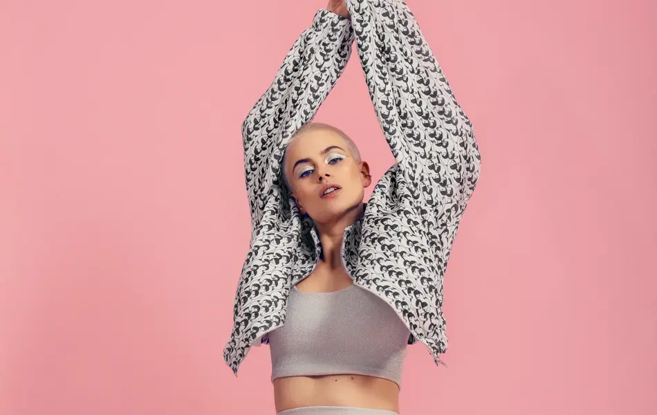 Dame strekker seg foran rosa vegg