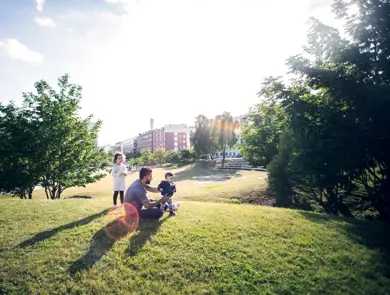 Mann leker med barn i en grønn park