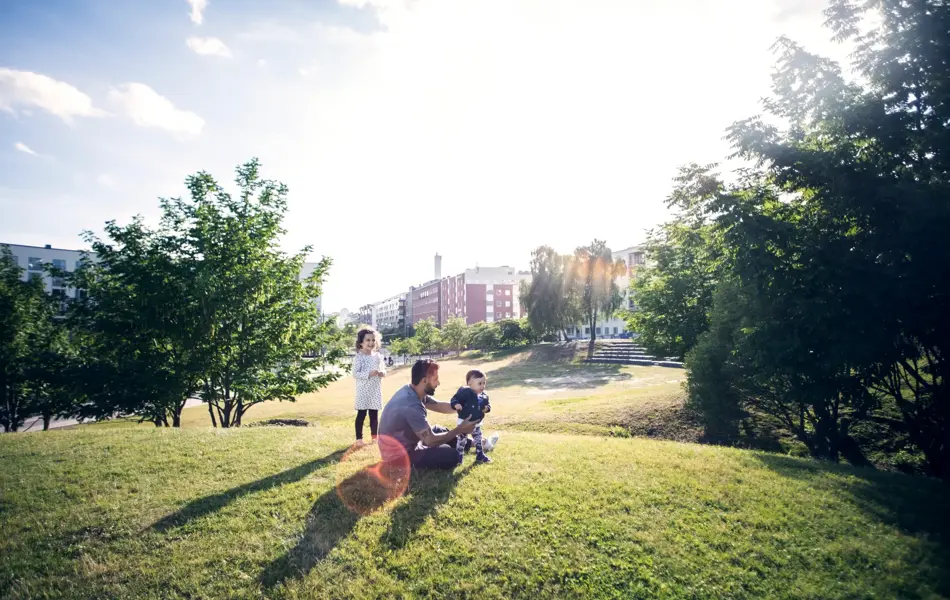 Mann leker med barn i en grønn park