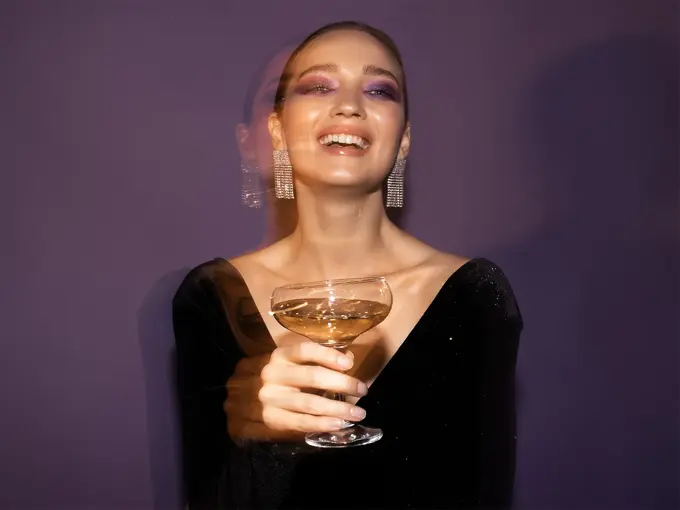 Dame som holder et champagne glass