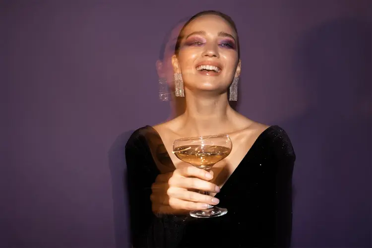 Dame som holder et champagne glass