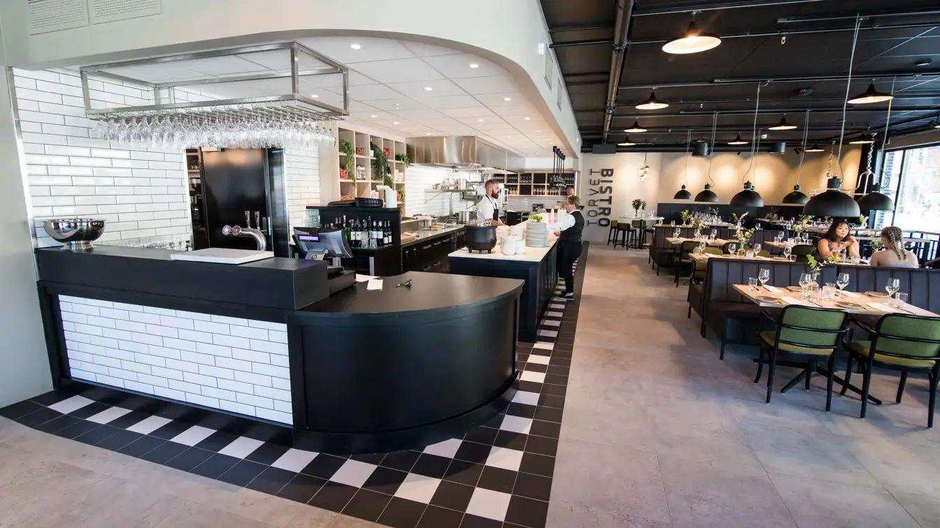 Oversikt over restauranten Restaurant med kokk og servitør som planlegger dagen på Torvet Bistro på Thon Hotel Parken i Kristiansand sentrum