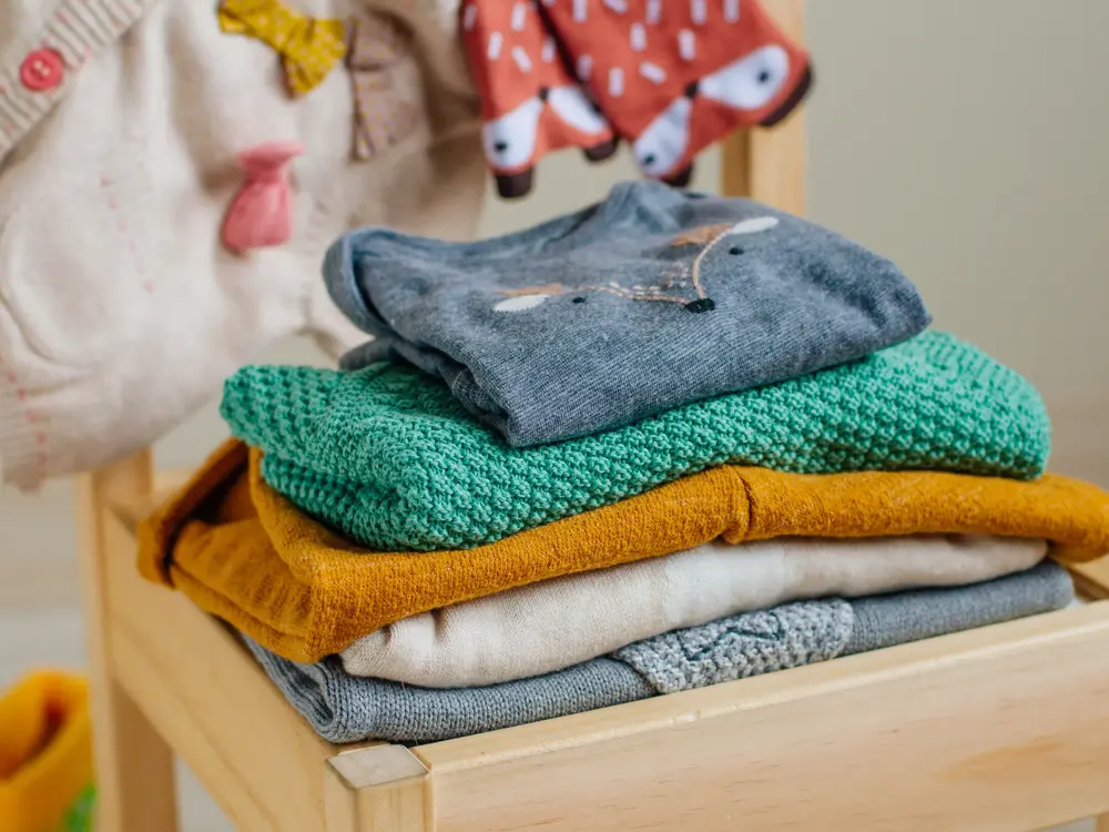 Baby organic clothes concept. Organic cotton clothing on the kids chair in children room. Selective focus.