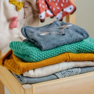 Baby organic clothes concept. Organic cotton clothing on the kids chair in children room. Selective focus.