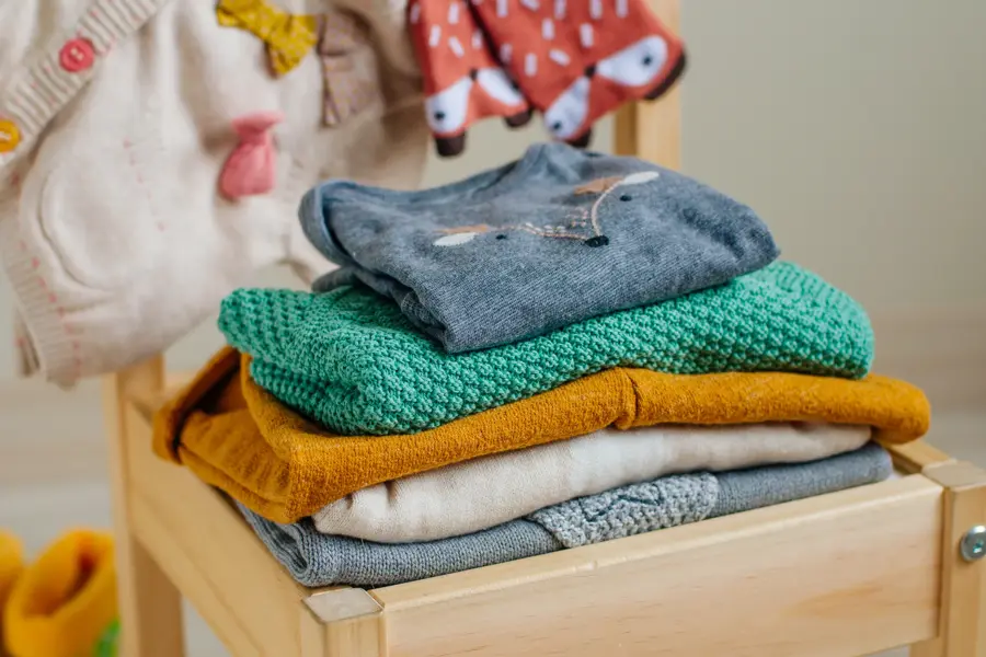 Baby organic clothes concept. Organic cotton clothing on the kids chair in children room. Selective focus.