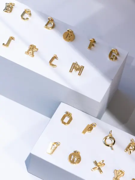 Bokstaver fra DAvid Andersen i gull til å henge på smykke