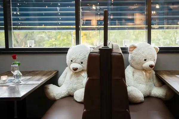 Bilde av store teddybjørner ved restaurantbord