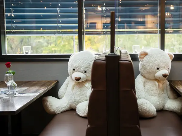 Bilde av store teddybjørner ved restaurantbord