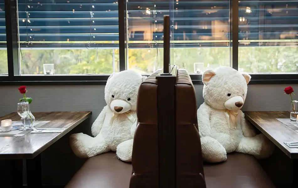 Bilde av store teddybjørner ved restaurantbord