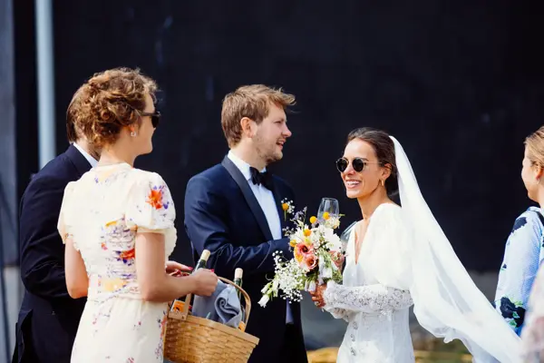 Nygift brudepar og sommerkledde bryllupsgjester