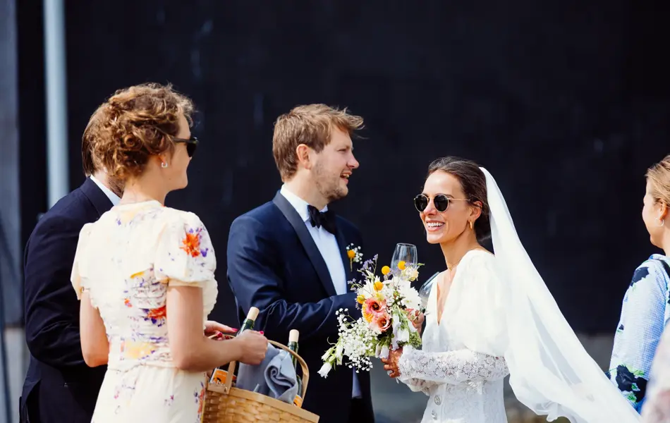 Nygift brudepar og sommerkledde bryllupsgjester