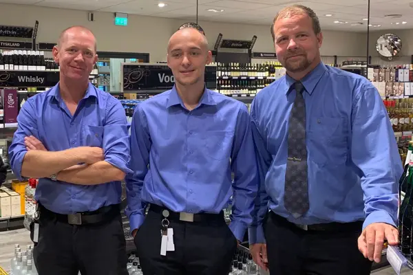 tre mannlige ansatte hos vinmonopolet