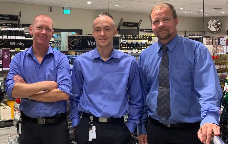 tre mannlige ansatte hos vinmonopolet