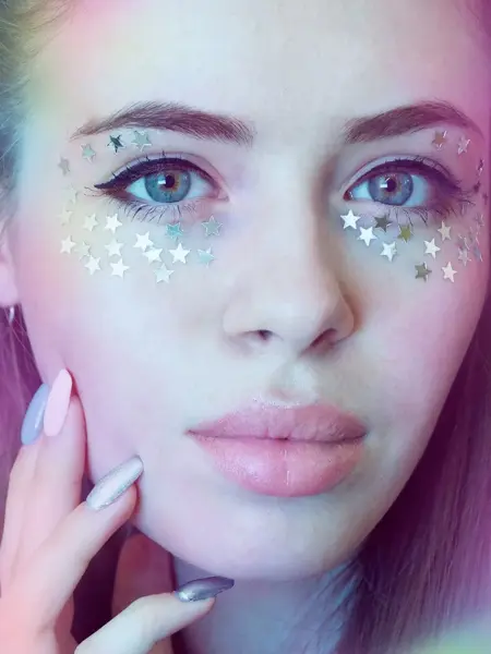 Nærbilde av en kvinne med stjerner klistret rundt øynene