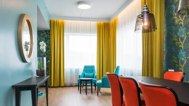 Suite med sofa, TV, spisebord, lenestol og gardiner