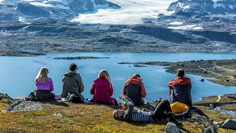 Gjeng med mennesker er på tur på fjellet 