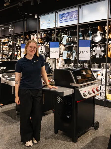 dame står ved grill i butikk