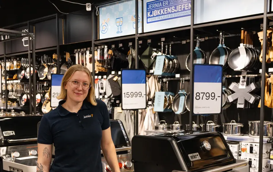 dame står ved grill i butikk
