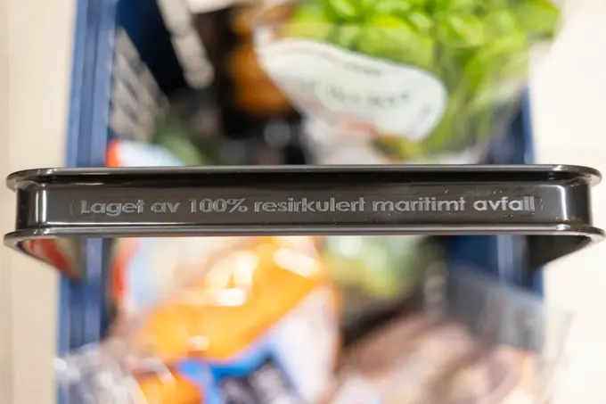 Handlekurv fra Rema 1000 med tekst på håndtaket "Laget av 100% resirkulert maritimt avfall"