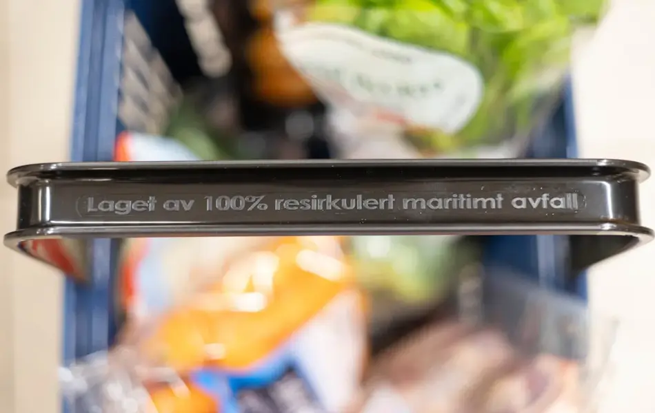 Handlekurv fra Rema 1000 med tekst på håndtaket "Laget av 100% resirkulert maritimt avfall"