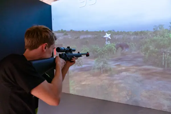 gutt spiller på skytesimulator