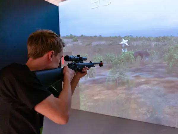 gutt spiller på skytesimulator