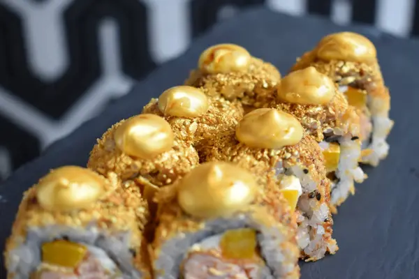 Sushi, maki med gullfarget strø og pynt