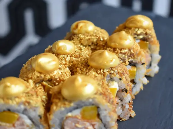 Sushi, maki med gullfarget strø og pynt
