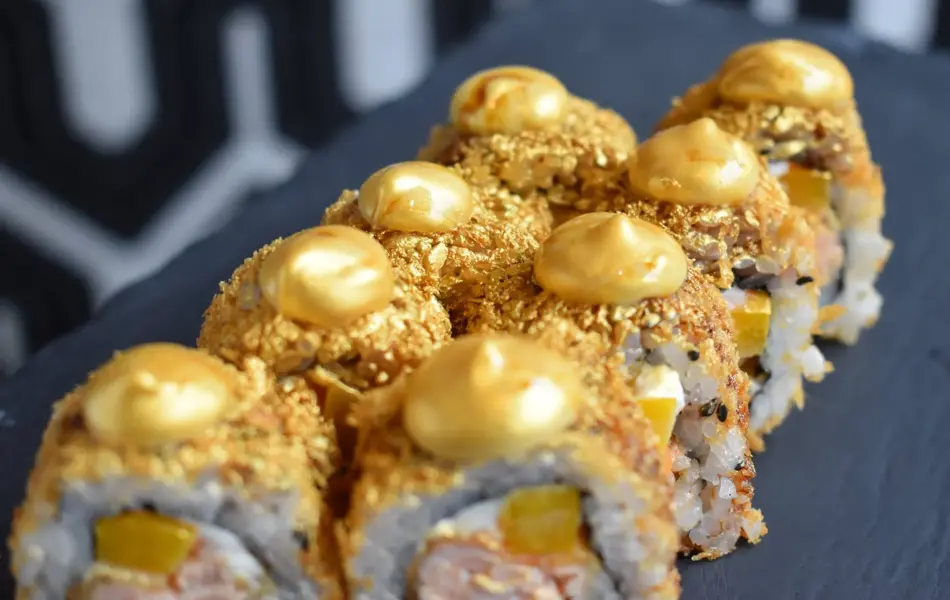 Sushi, maki med gullfarget strø og pynt