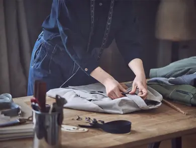 Dame som måler opp lengden på en skjorte