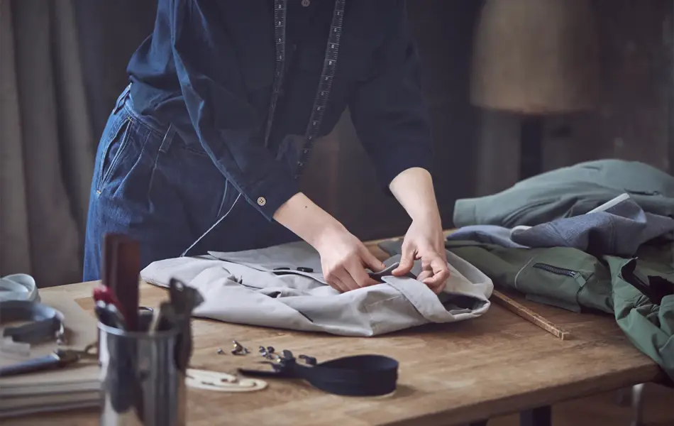 Dame som måler opp lengden på en skjorte