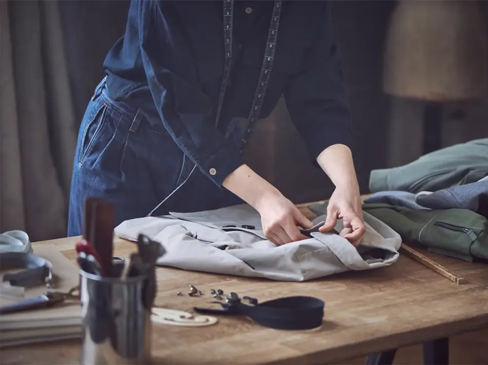 Dame som måler opp lengden på en skjorte