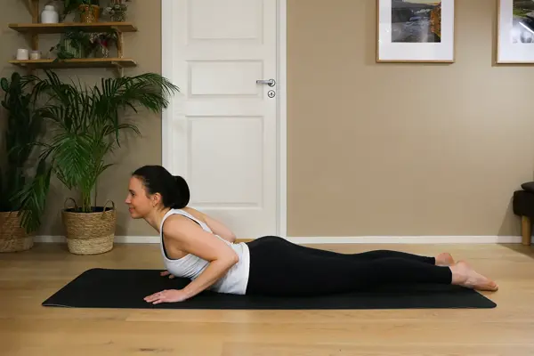 Anna viser Pilates-øvelser på treningsmatte på gulvet