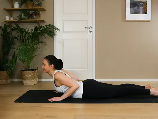 Anna viser Pilates-øvelser på treningsmatte på gulvet