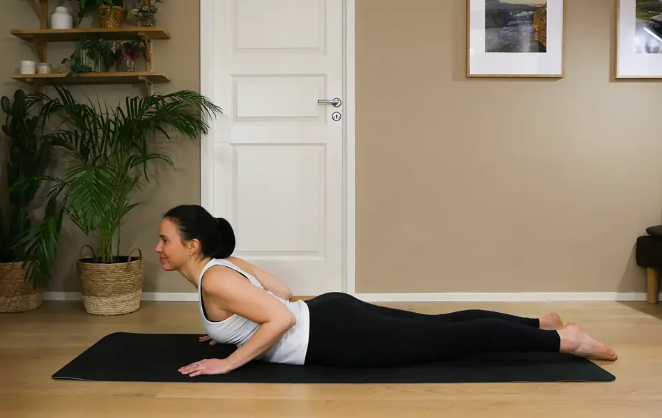 Anna viser Pilates-øvelser på treningsmatte på gulvet