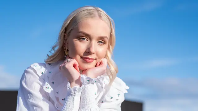 Jente med blå himmel i bakgrunn