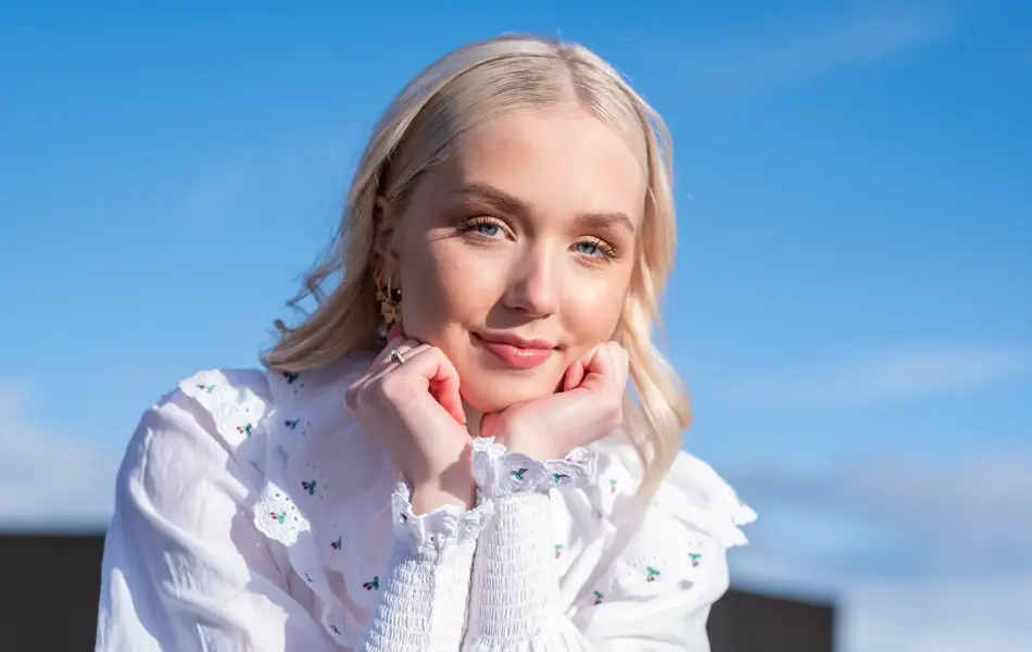 Jente med blå himmel i bakgrunn