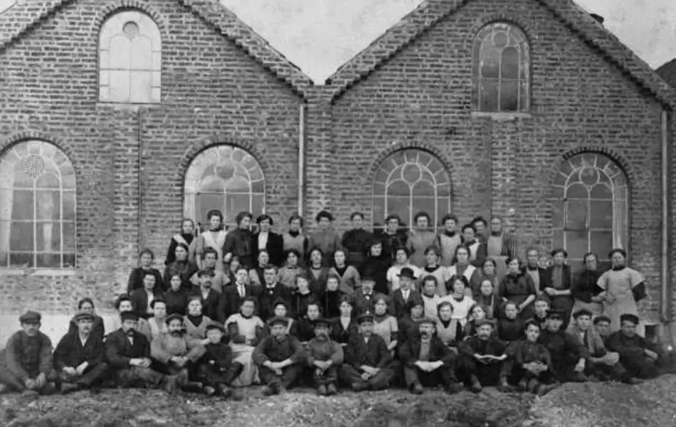 svarthvitt gruppebilde foran den gamle ullvarefabrikken