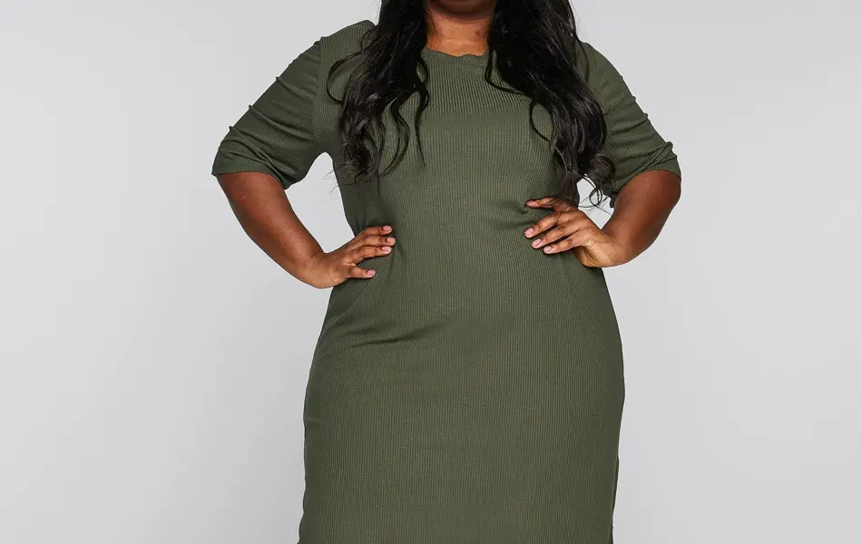 Jente med sort langt hår og grønn ribbestrikket kjole