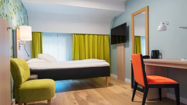 Skrivebord, stol, seng og smart-TV i enkeltrom på Thon Hotel Tønsberg Brygge