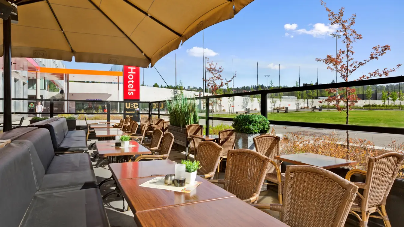 Uteservering med sittegrupper og stor parasoll på Restaurant Egon ved Thon Hotel Ullevål Stadion