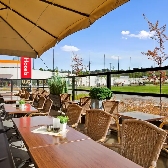 Uteservering med sittegrupper og stor parasoll på Restaurant Egon ved Thon Hotel Ullevål Stadion