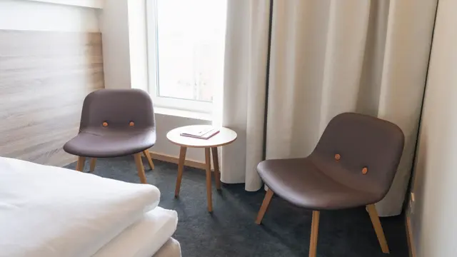 Dobbeltrom med sittegruppe, to stoler og et lite bord.