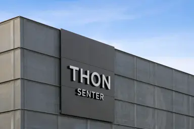 Fasadebilde av Thon Senter Vågsbygd med Thon Senter Logo.