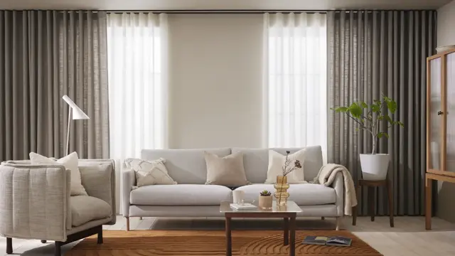 Stue med lyse sofaer og grå gardiner