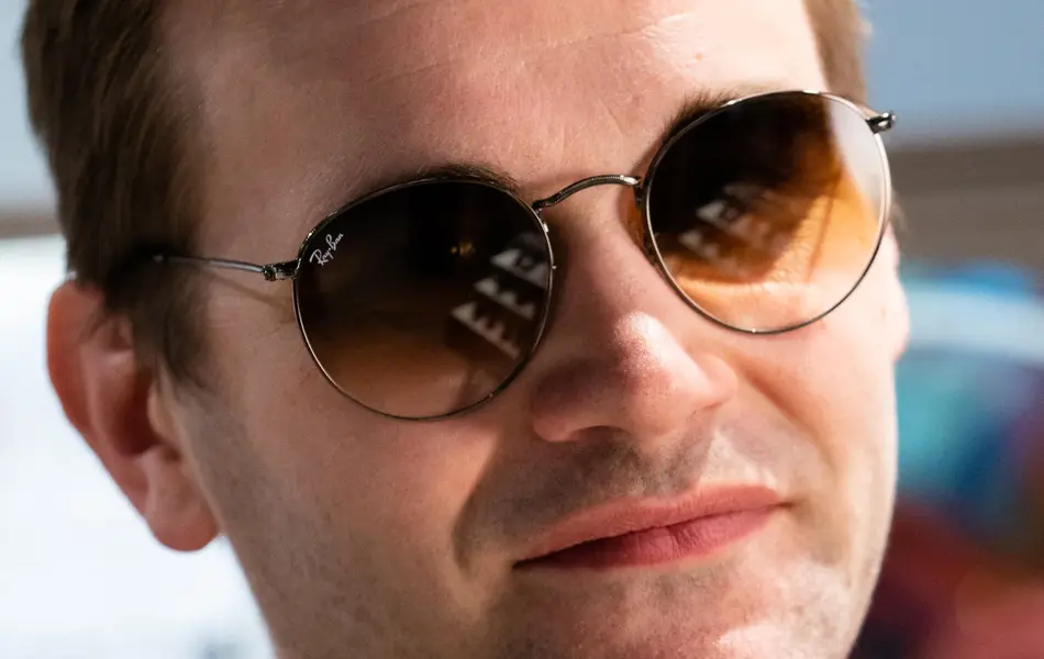 Gutt med blondt hår har på seg helt runde solbriller