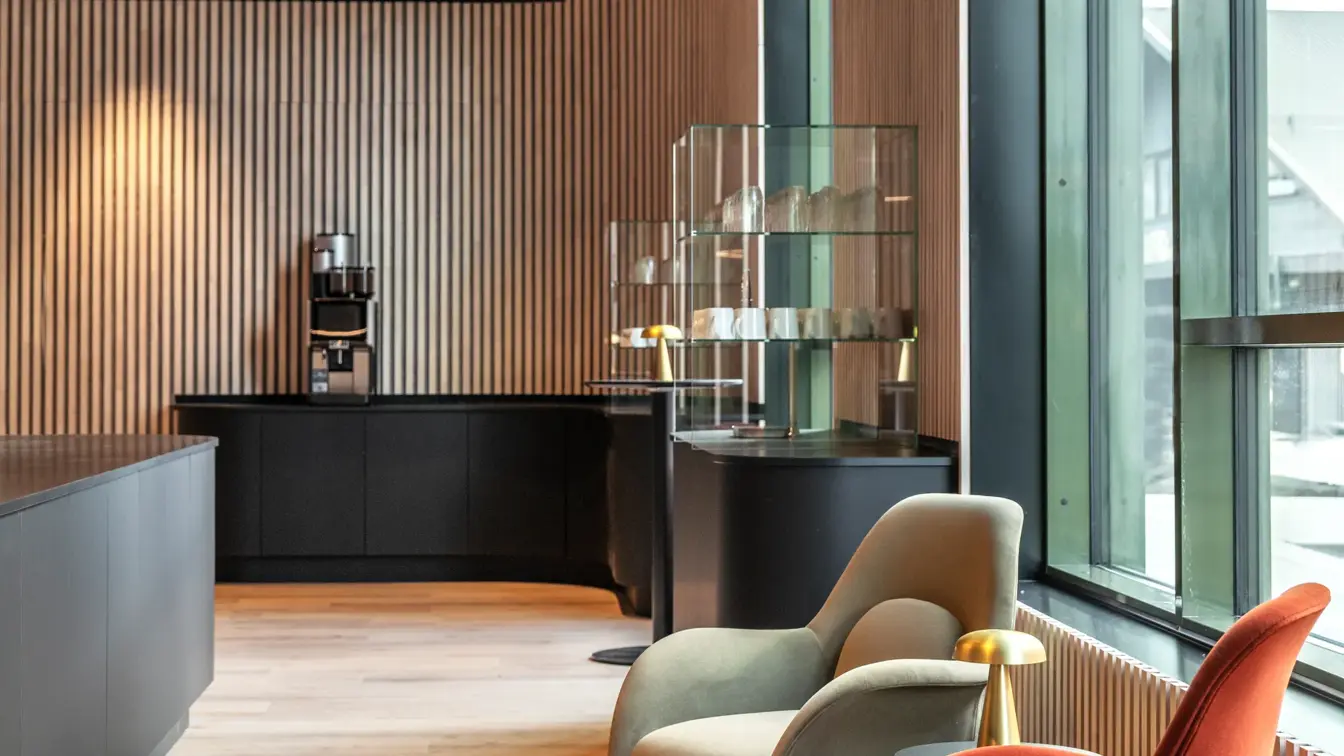 Område i lobby med kaffemaskin og lenestoler.