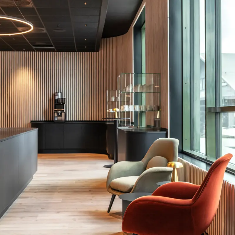 Område i lobby med kaffemaskin og lenestoler.