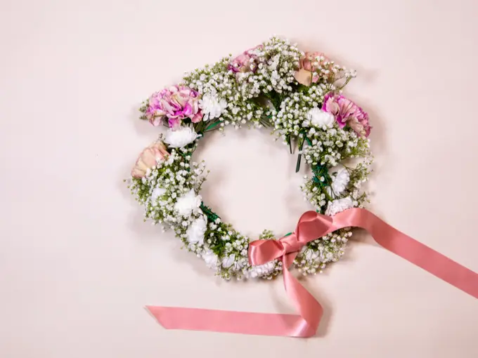 Ferdiglaget blomsterkrans med rosa sløyfe