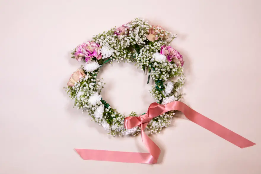 Ferdiglaget blomsterkrans med rosa sløyfe